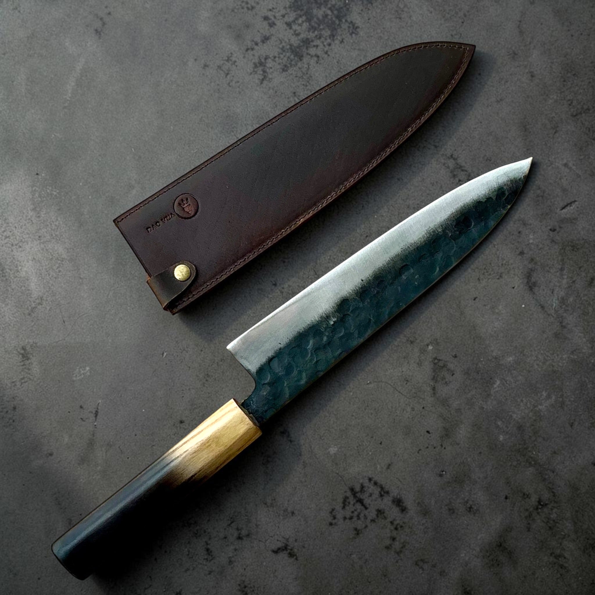 Dao Vua V3 Kuro Tsuchime Gyuto 210mm beside its leather sheath