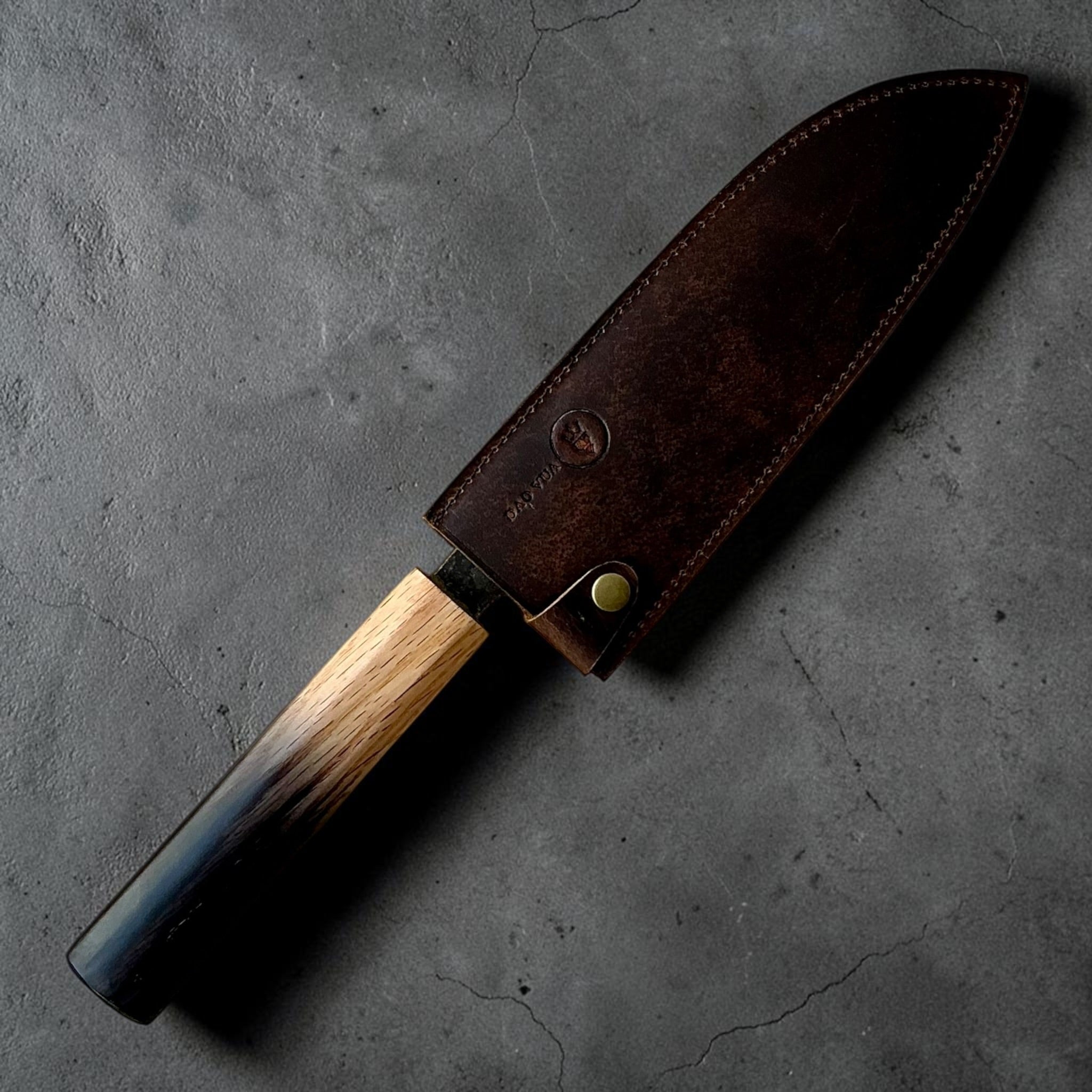 Dao Vua V3 52100 Kuro Tsuchime Santoku with burnt wood handle in leather sheath
