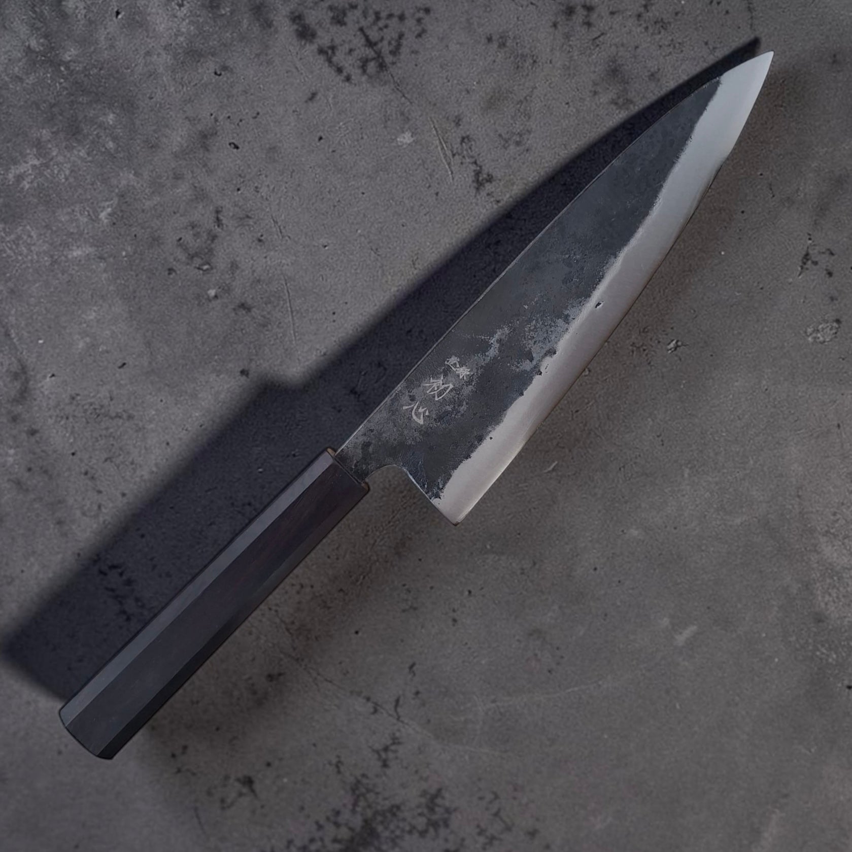 Angled view of Hatsukokoro Kurogane Blue #2 gyuto and ebony handle