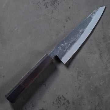Angled view of the Hatsukokoro Kurogane Blue #2 honesuki and rustic kurouchi finish