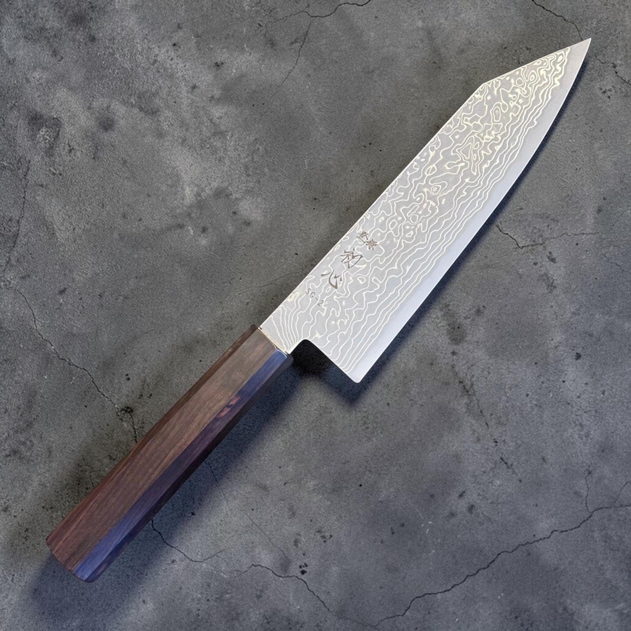 Hatsukokoro Ryuhyo SG2 Damascus Migaki Bunka with Mono Ebony Handle, angled front view showing the Damascus pattern and octagonal mono ebony wa handle.