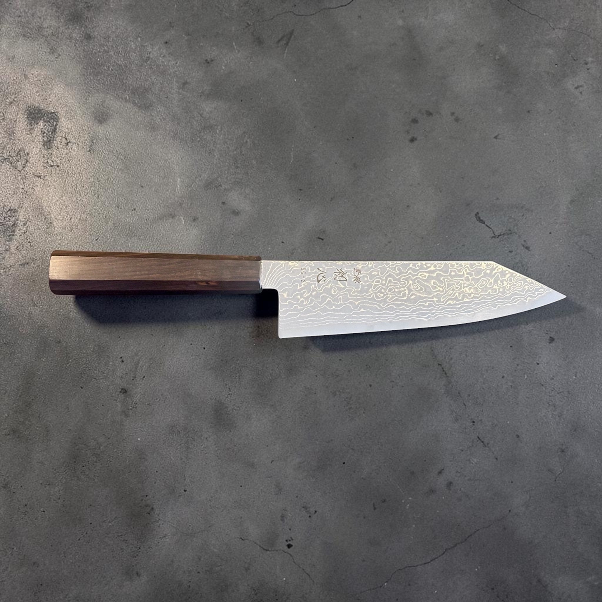 Hatsukokoro Ryuhyo SG2 Damascus Migaki Bunka with Mono Ebony Handle, full side profile of the blade and handle on a gray background.