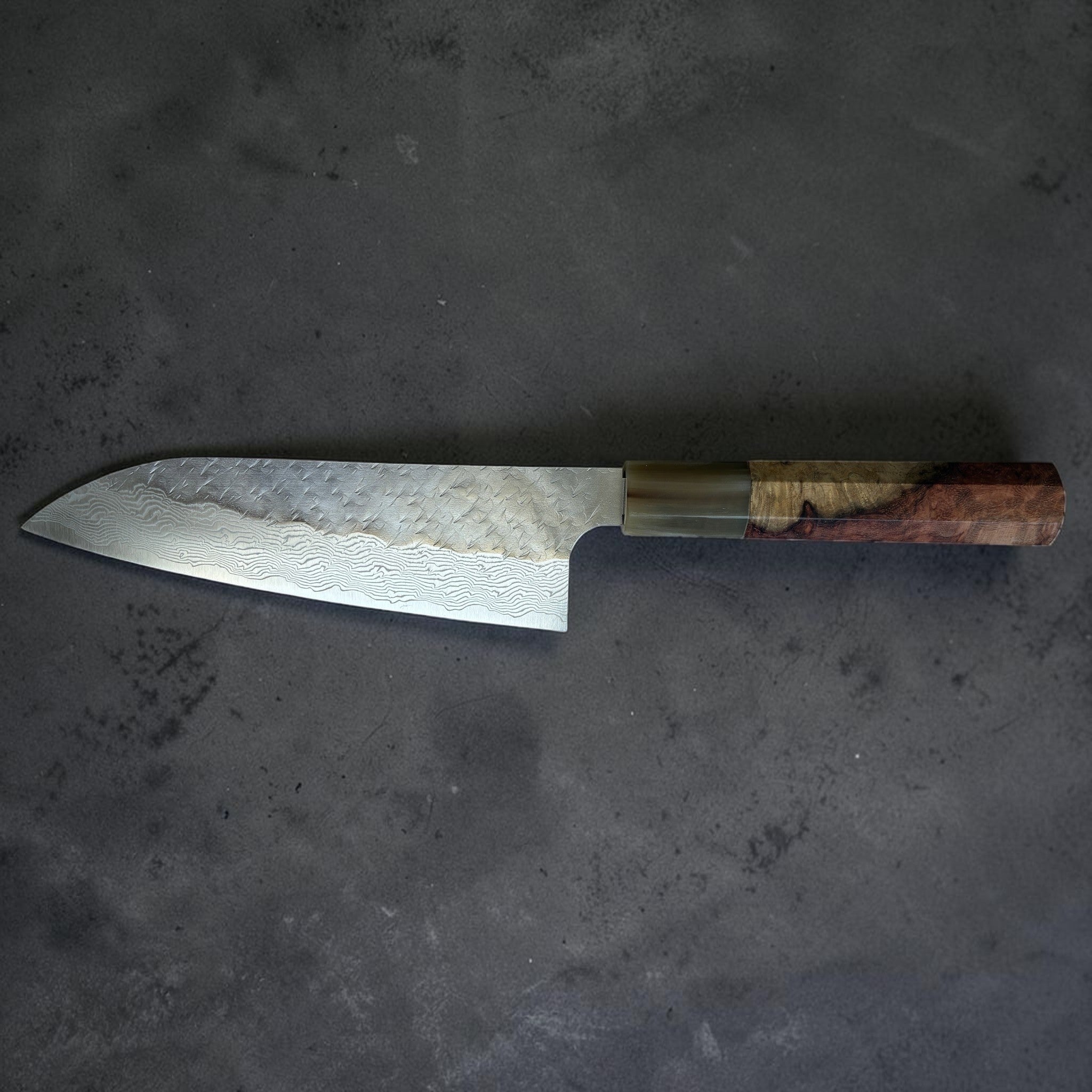 Nigara SG-STRIX Tsuchime Damascus Santoku 165 mm, side profile showing Damascus pattern, tsuchime finish, and custom handle.