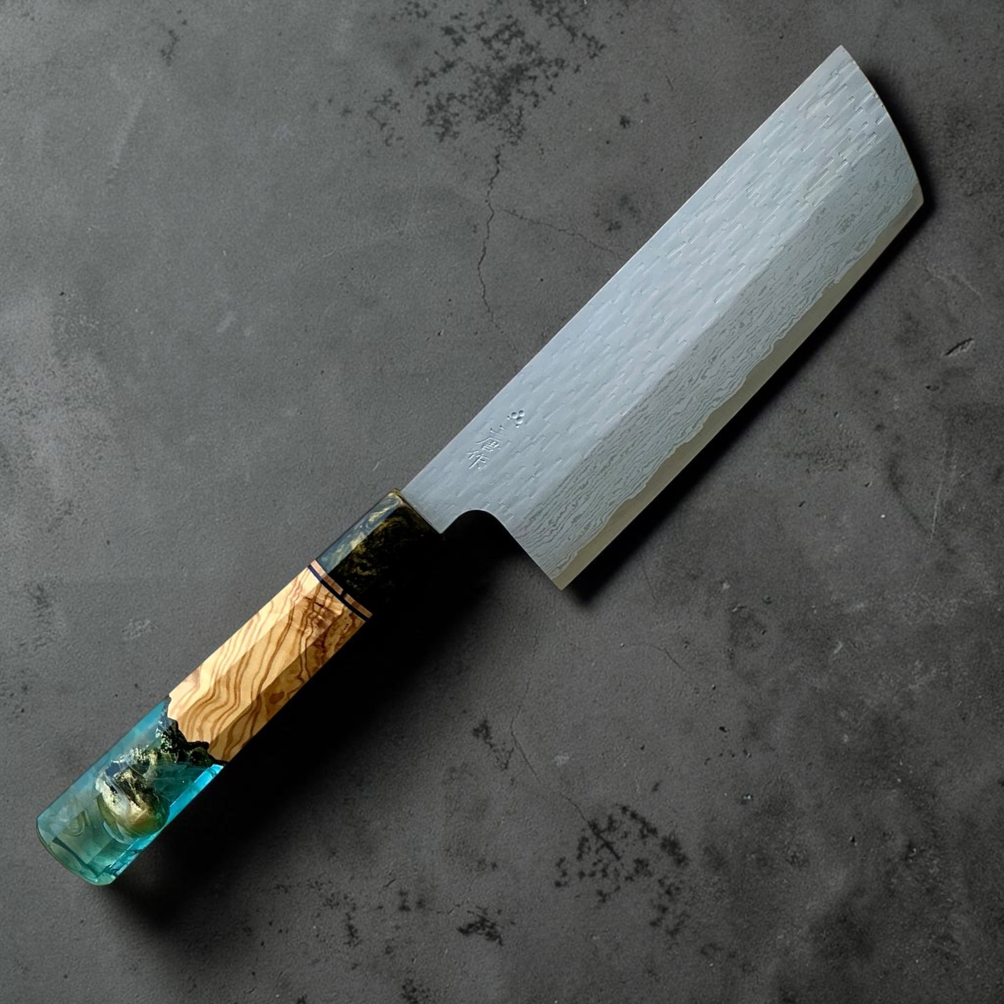 Nigara VG-XEOS polished tsuchime nakiri 165mm with blue-green Prisma resin and wood custom handle, reverse view.