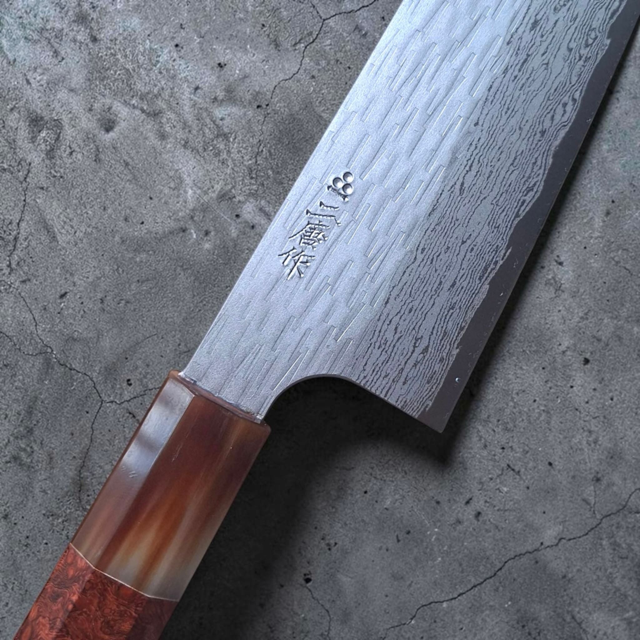 Nigara VG XEOS Tsuchime Gyuto 210 mm close-up showing the kanji, tsuchime texture, Damascus pattern, horn ferrule, and amboyna burl handle.