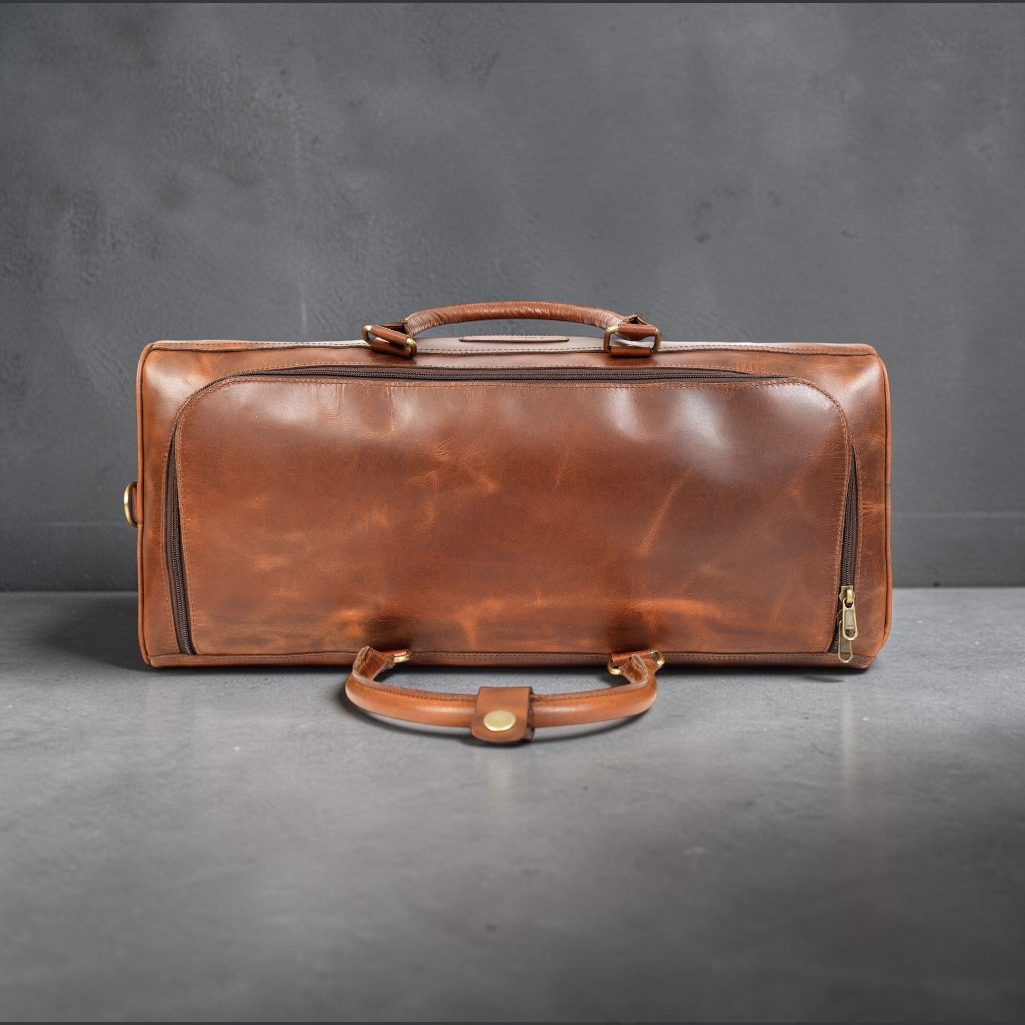 The Hidemaster Aspen Duffle Chef Bag in rustic brown leather, long side view showing zipper, handles, and brass zipper pull.