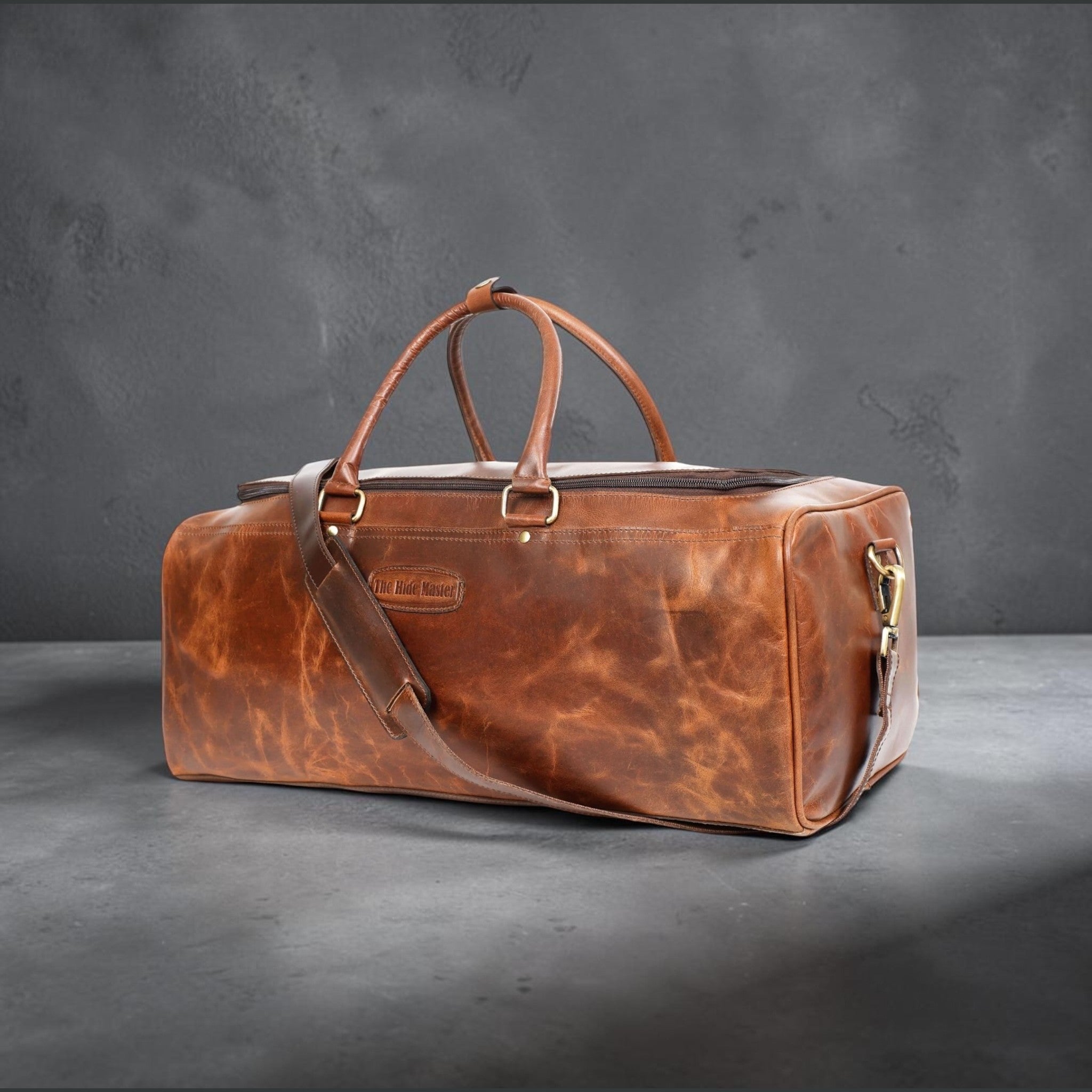 The Hidemaster Aspen Duffle Chef Bag in rustic brown leather, angled side view showing leather grain, shoulder strap, and brass hardware.