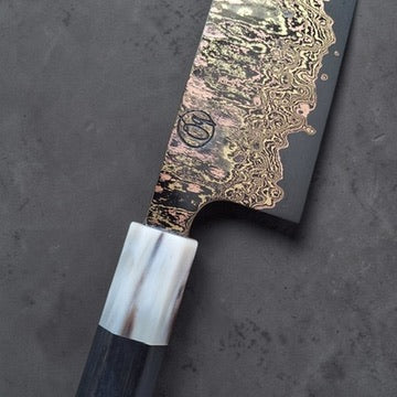 Close-up of the Tu Nguyen maker mark, rainbow Damascus blade and horn ferrule