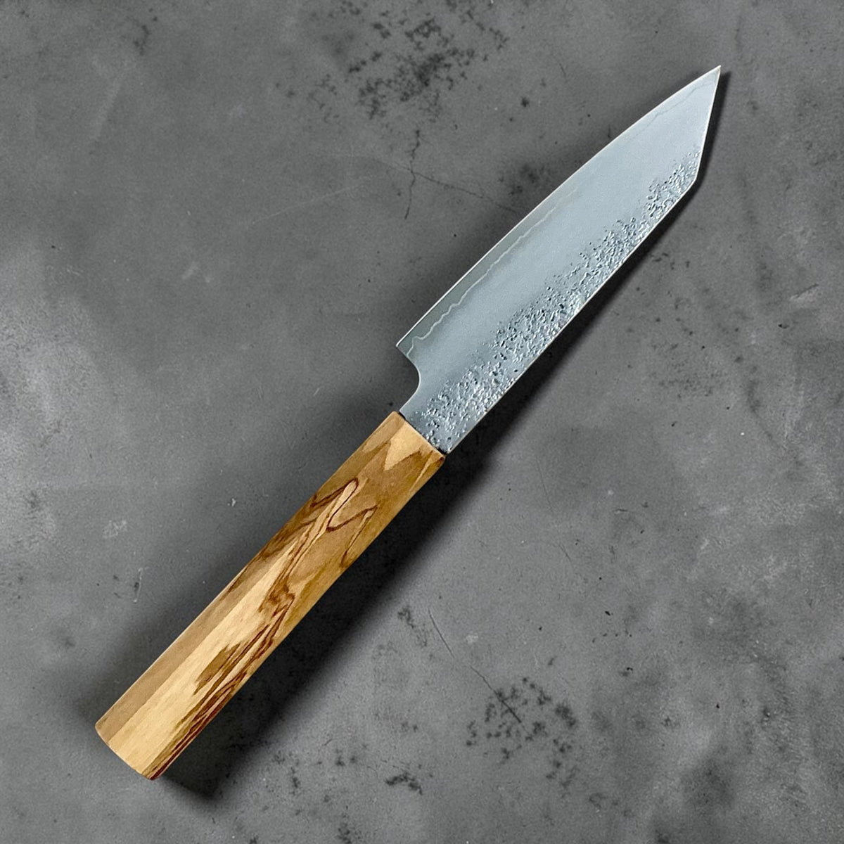 Hatsukokoro Ginrei Silver 3 Kiritsuke Petty 125mm: Reverse side angled view showing Nashiji finish and olive wood handle