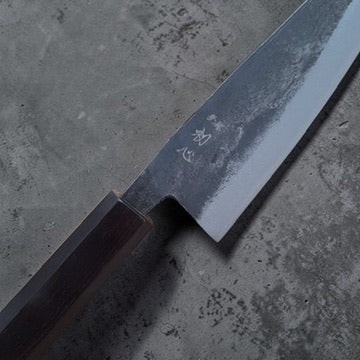 Close-up of the Hatsukokoro Kurogane honesuki blade, kanji and kurouchi finish