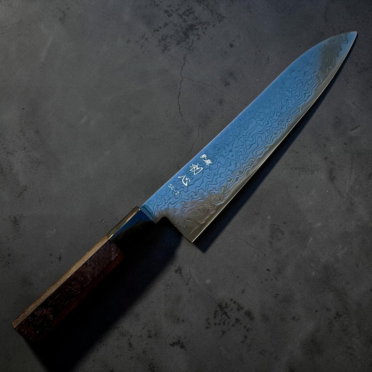 Hatsukokoro Ryuhyo SG2 Black Damascus Gyuto 210mm with walnut handle, angled logo-side view
