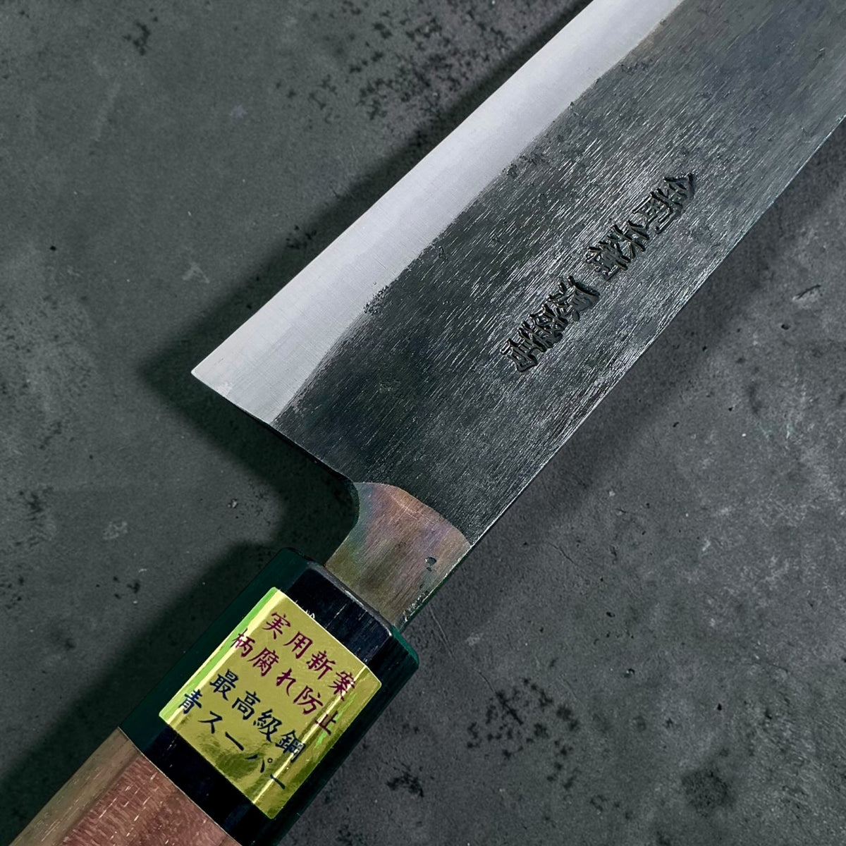 Moritaka Aogami Super Kiritsuke 210mm, primo piano dell'incisione sulla lama e della ghiera del manico