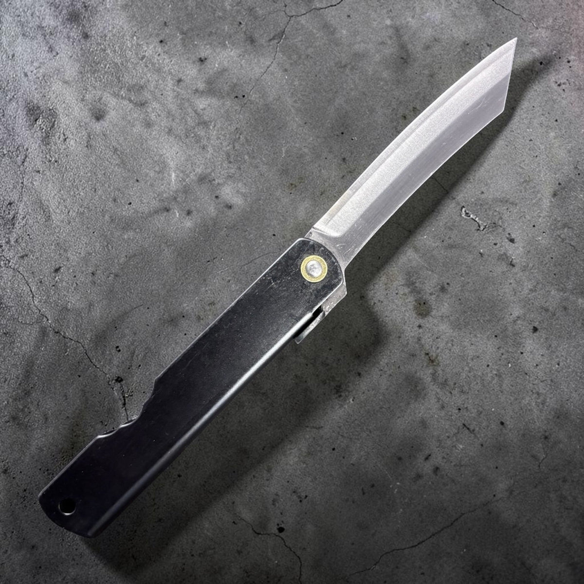 Reverse side of Nagao Higonokami SK carbon steel medium friction folder with plain black handle and SK carbon blade, studio-lit on dark background. #size_medium - black