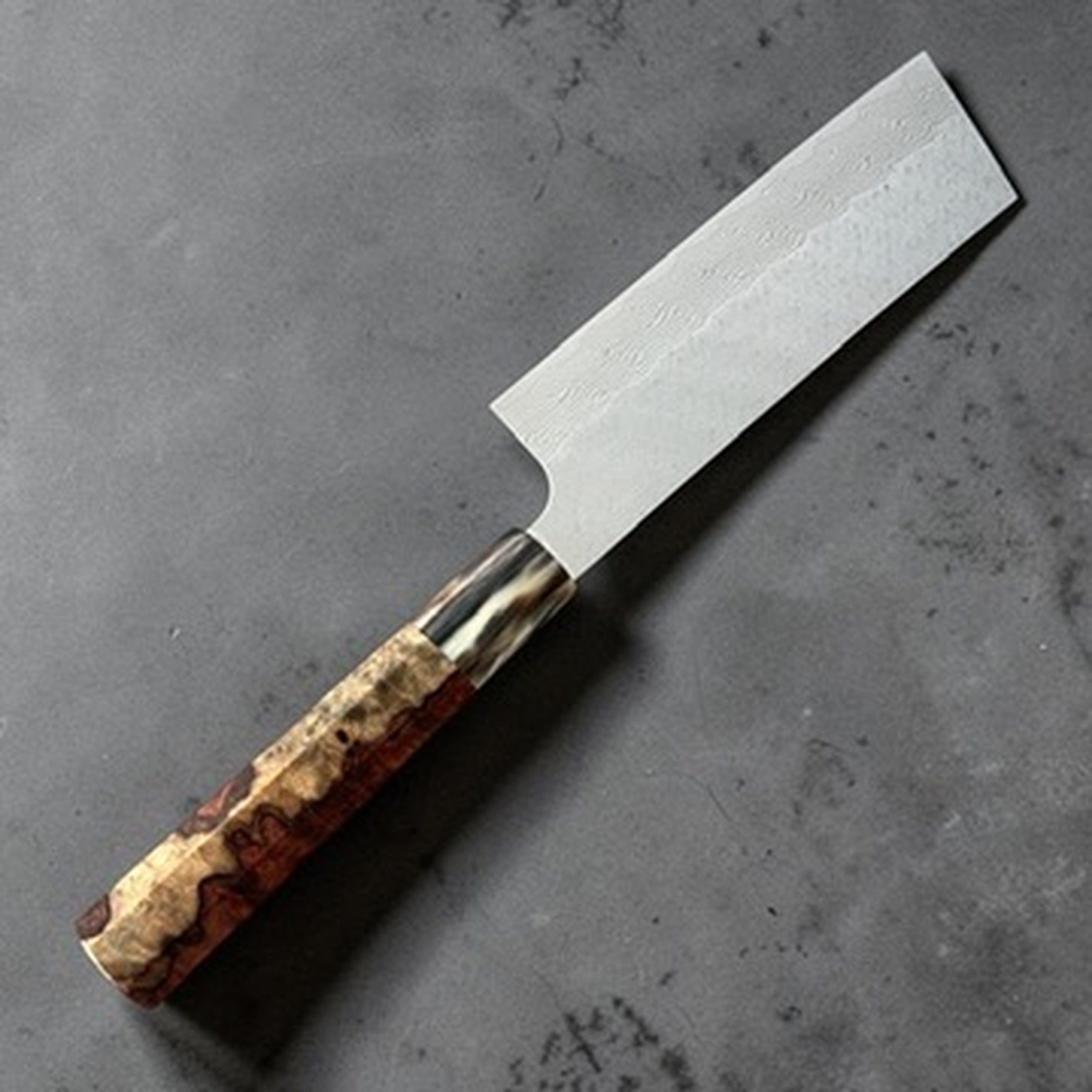 Nigara SG-STRIX Damascus Hakata Kiritsuke Nakiri with Amboyna Burl Handle, angled full view showing the SG-STRIX Damascus blade and amboyna burl handle.