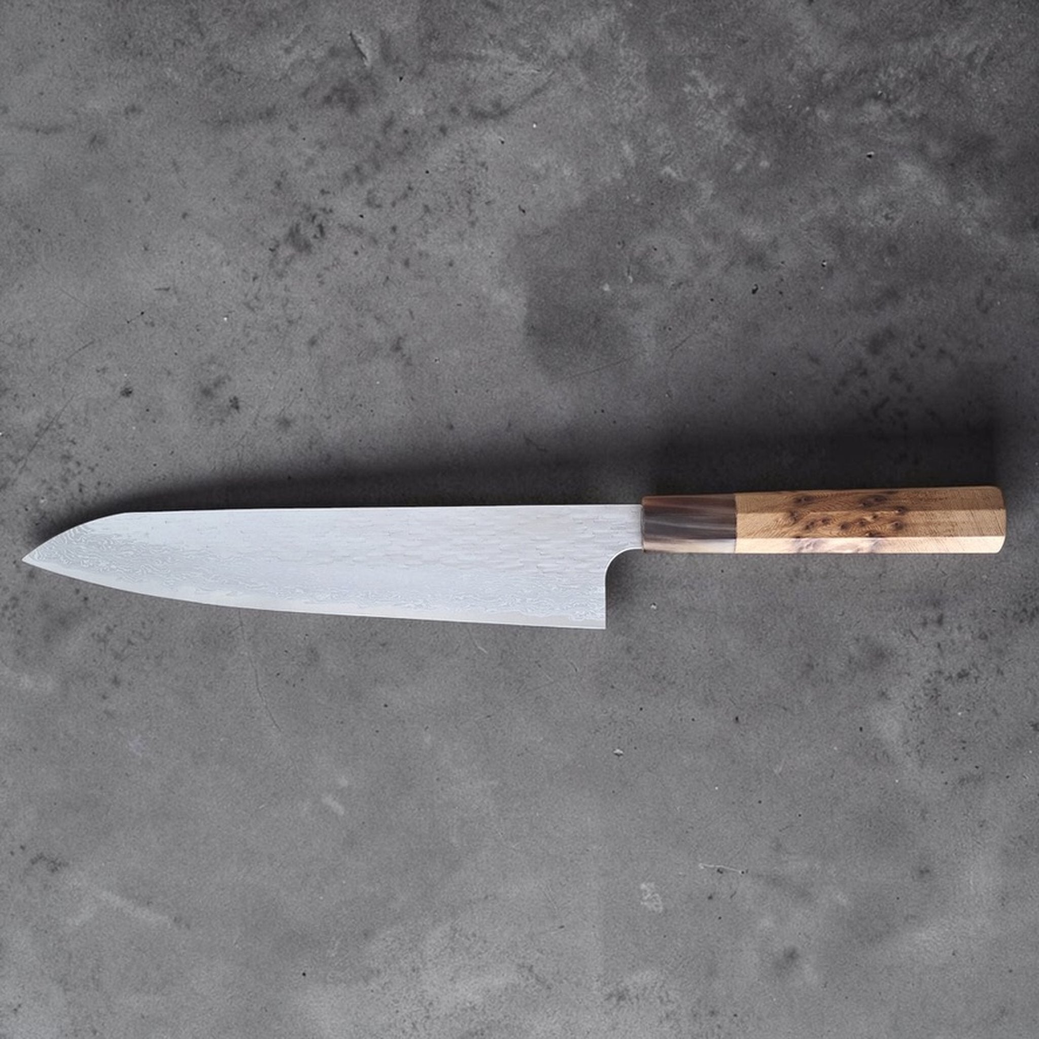 Nigara VG XEOS Tsuchime Gyuto 240 mm with cypress and horn handle, reverse full blade profile showing tsuchime Damascus pattern.