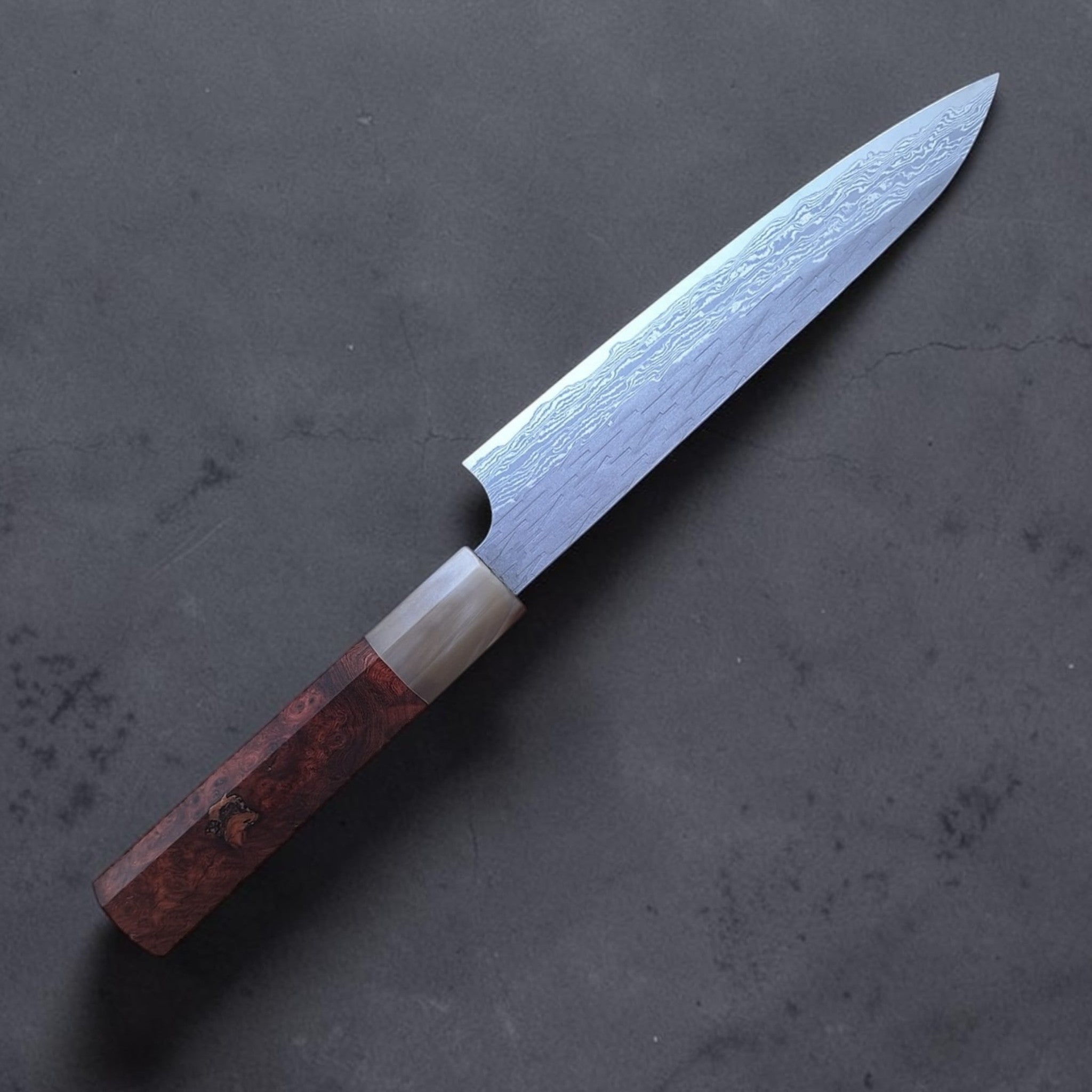 Angled view of blade finish and octagonal Amboyna Burl wa handle.