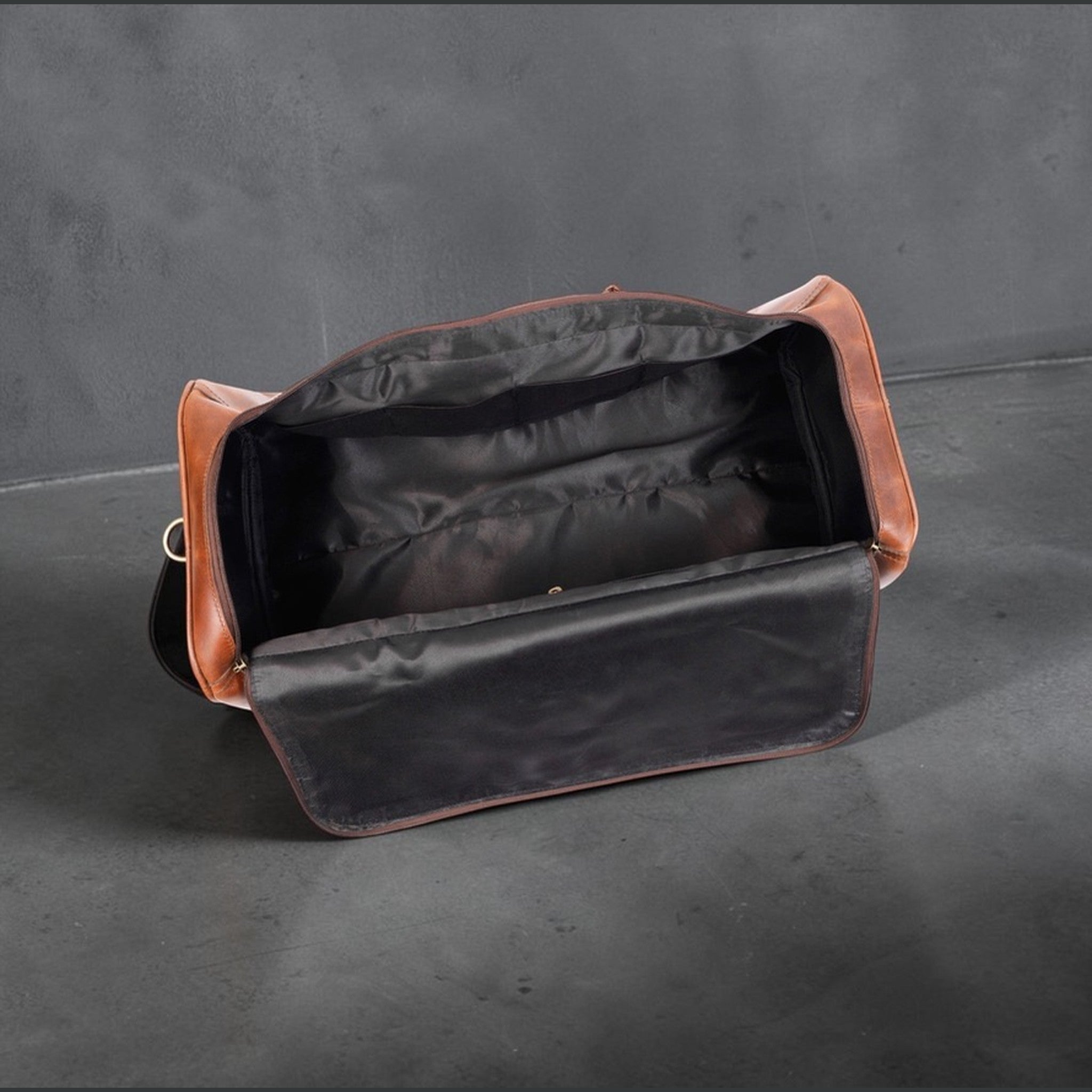 The Hidemaster Aspen Duffle Chef Bag in rustic brown leather, open front view showing the black fabric lining and wide storage opening.