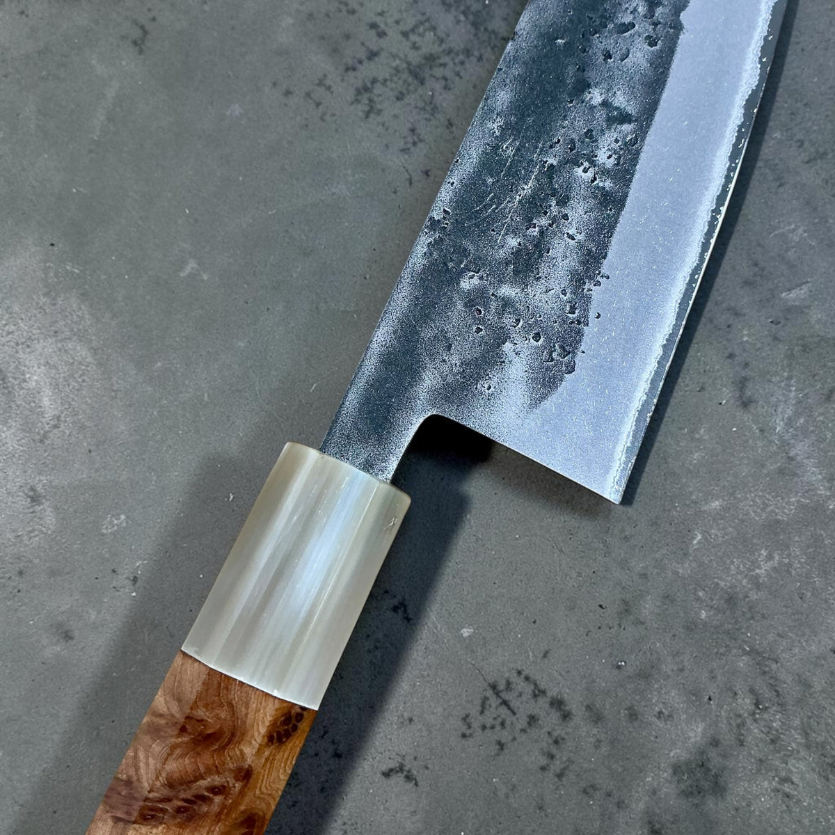 Close-up of the cypress handle, buffalo horn ferrule and nashiji blade finish