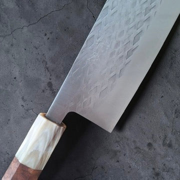 Close-up of Tokushu Knife SLD Tsuchime Nakiri blade face with hammered tsuchime finish and light ferrule