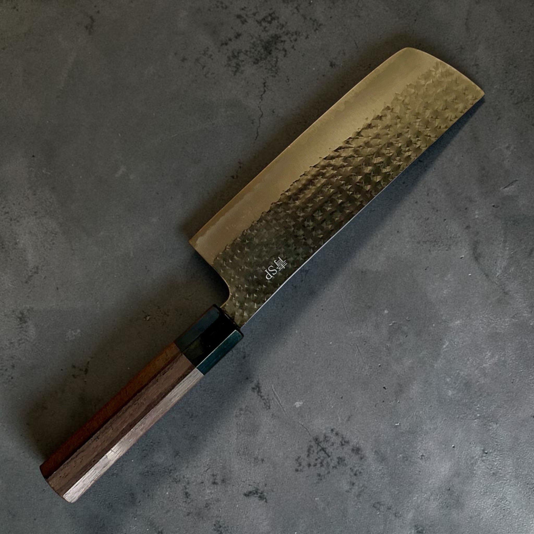 Vista posteriore angolata dello Yu Kurosaki Kokusen AS Nakiri con finitura Kokusen tsuchime